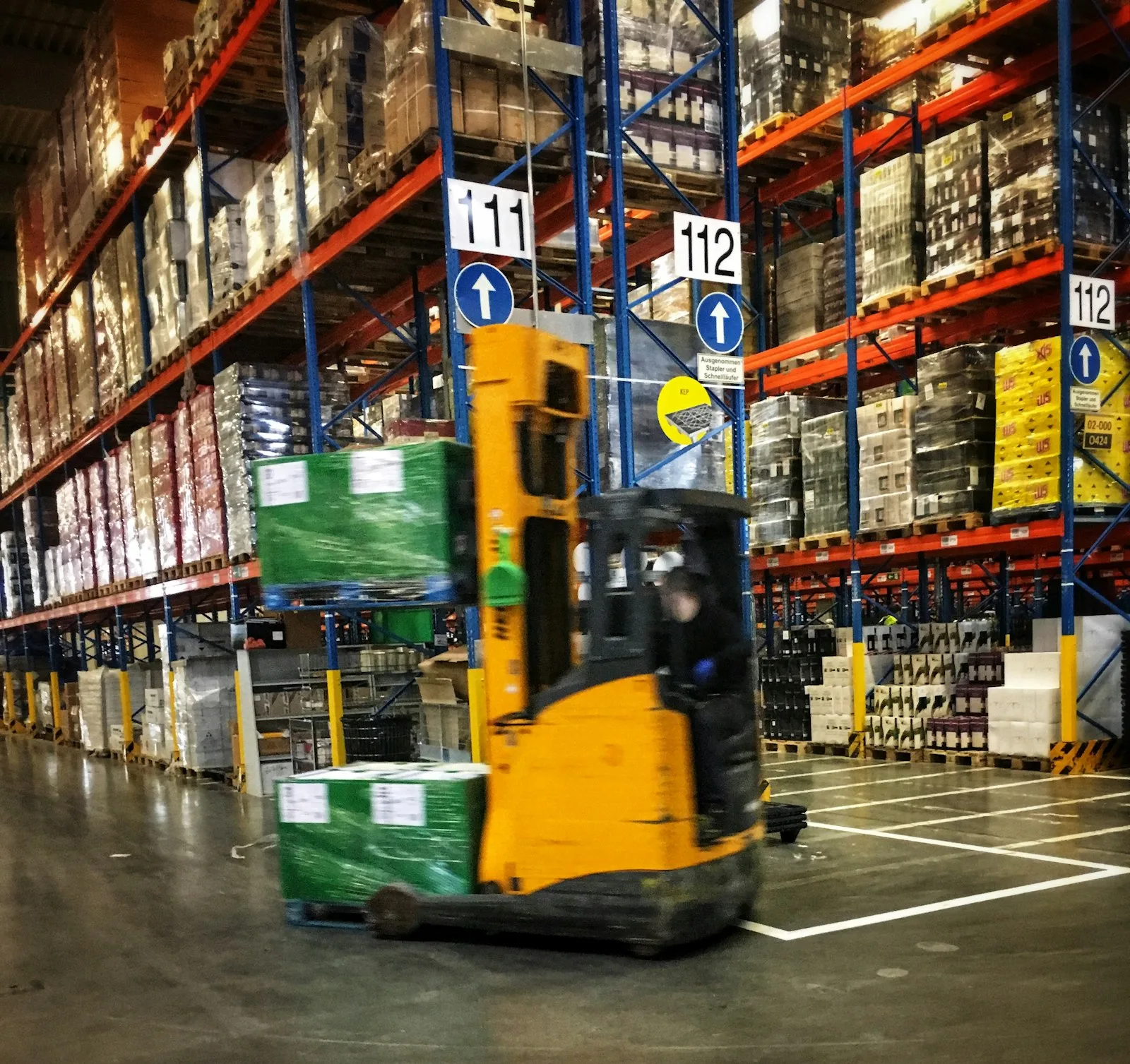 Paletlerle dolu depoda ilerleyen forklift