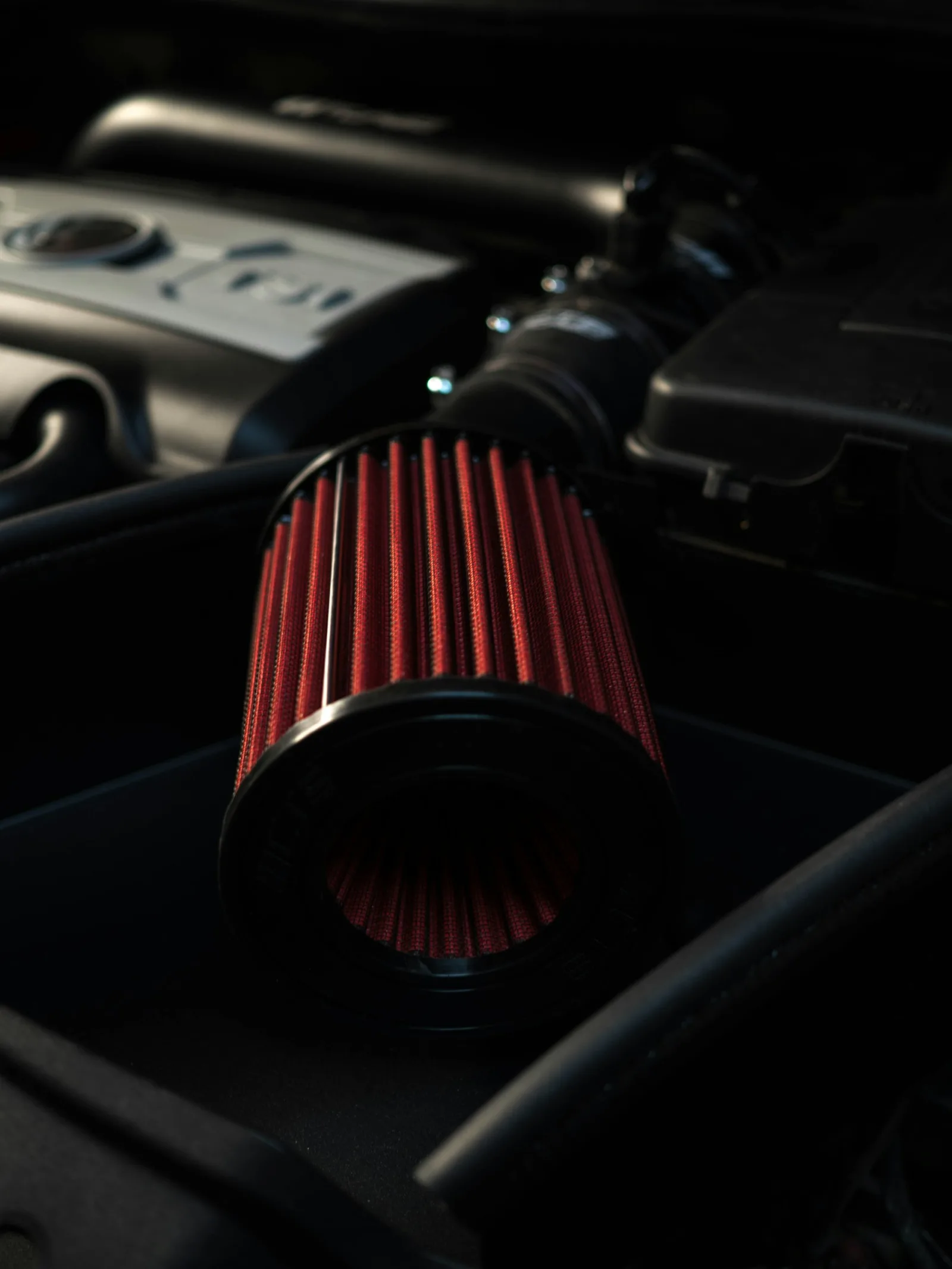 Nahaufnahme eines roten konischen Luftfilters im Motorraum