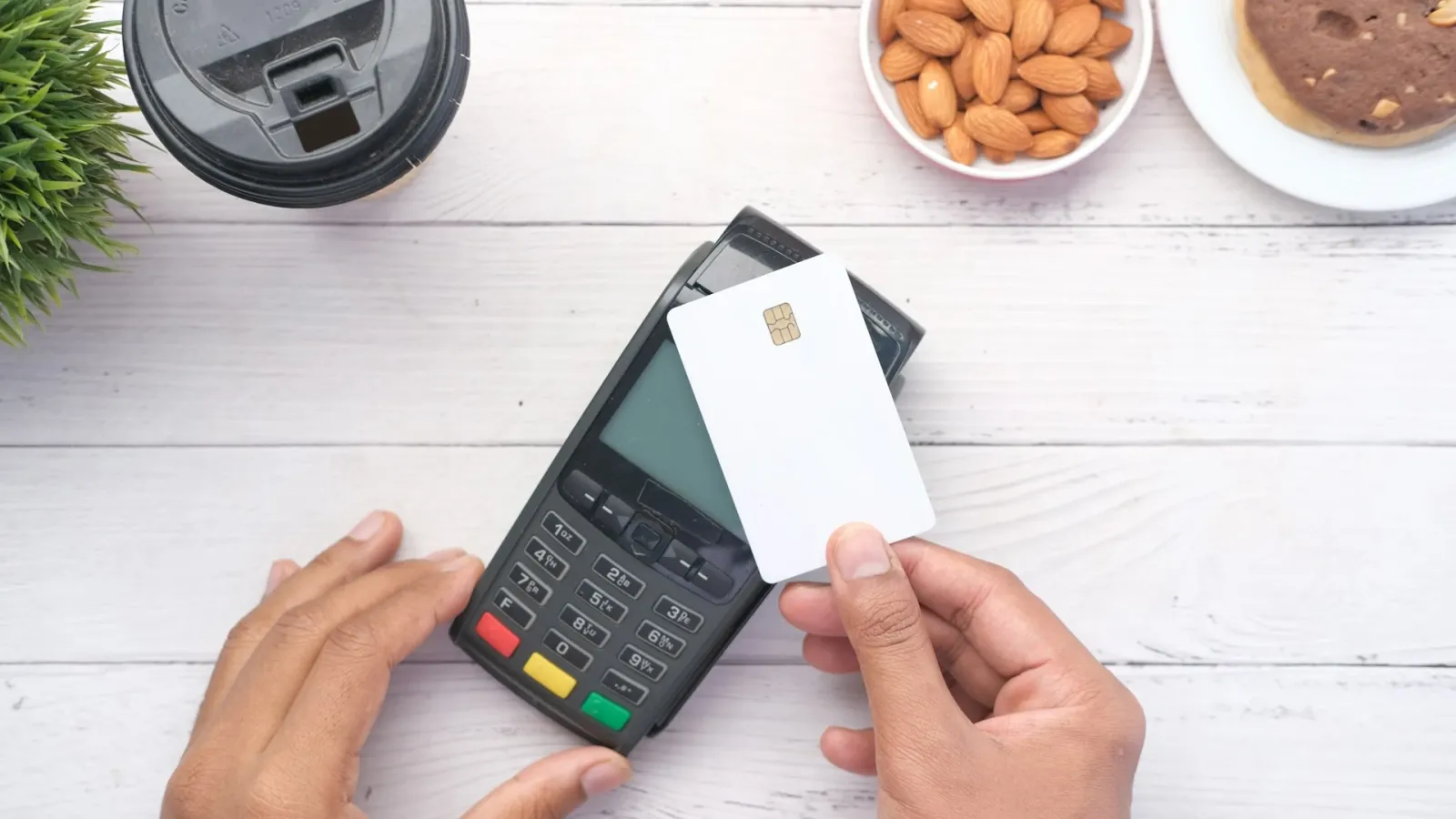 A chip card being held up to a card payment terminal on a table